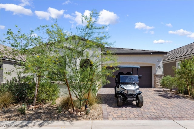 12 Tatahatso Point St, Henderson, NV 89011 - view of front of property featuring decorative driveway, stucco siding, a garage, and stone siding