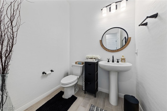 12 Tatahatso Point St, Henderson, NV 89011 - half bath with wood finish floors, toilet, baseboards, and a sink