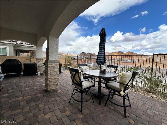 view of patio with area for grilling, fence, and outdoor dining area