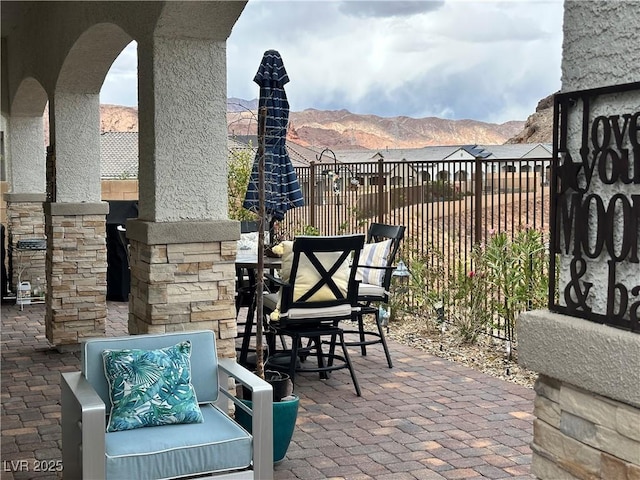view of patio / terrace featuring a mountain view and fence