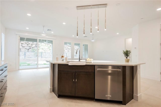 kitchen with light countertops, stainless steel dishwasher, a sink, dark brown cabinetry, and a kitchen island with sink