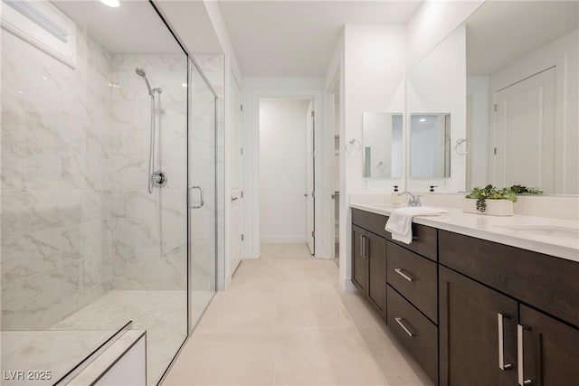 full bathroom featuring double vanity, tile patterned floors, a marble finish shower, and a sink