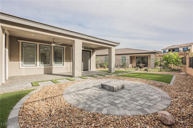 back of house with fence, a patio, a ceiling fan, and stucco siding