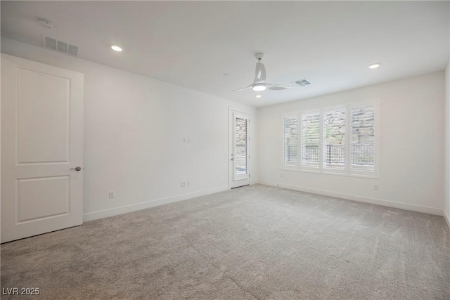 carpeted spare room featuring visible vents, a ceiling fan, and baseboards