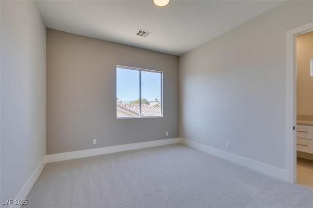 empty room featuring visible vents, baseboards, and light carpet