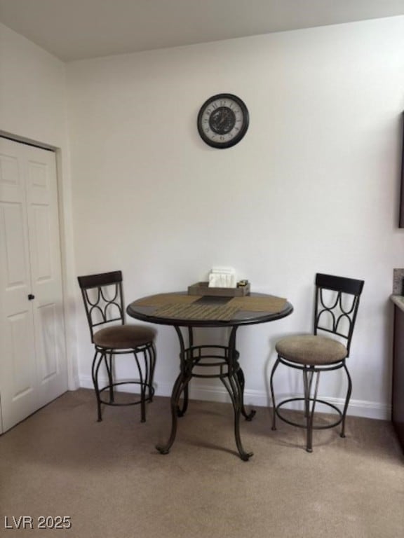 dining area with light carpet and baseboards