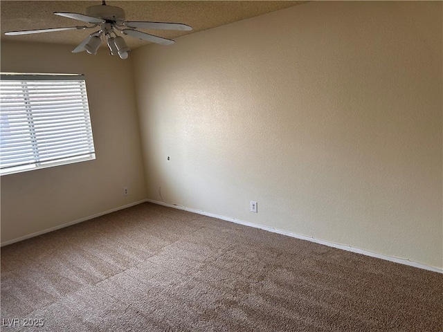 carpeted empty room featuring ceiling fan and baseboards