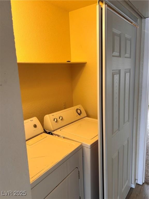 laundry area with washer and dryer and dark wood-type flooring