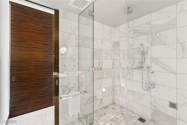 bathroom with a shower stall and visible vents