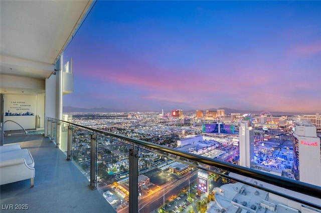 balcony at dusk featuring a city view