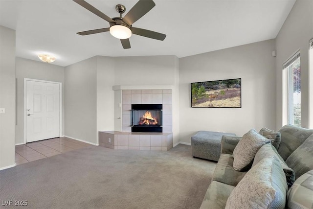 tiled living area with a ceiling fan, baseboards, carpet floors, and a fireplace
