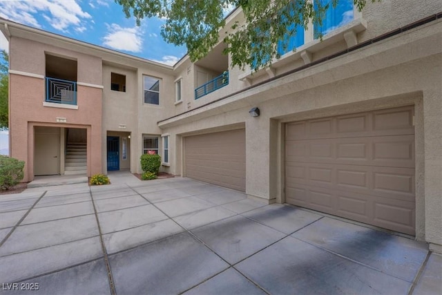 view of front facade featuring stucco siding, an attached garage, and driveway