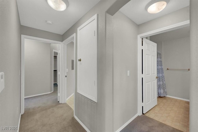 hall with baseboards and carpet flooring