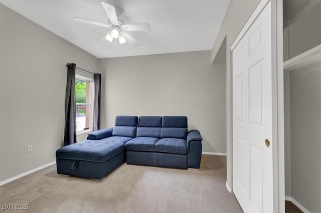 carpeted living room with a ceiling fan and baseboards