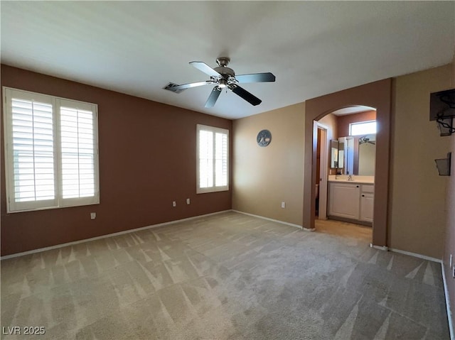 7173 Dravite Ct, Las Vegas, NV 89148 - empty room with arched walkways, a ceiling fan, light carpet, and baseboards