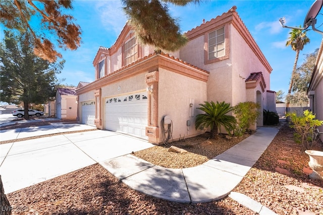 view of side of home featuring an attached garage, concrete driveway, a tiled roof, and stucco siding