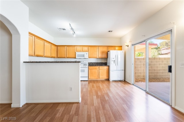 kitchen featuring arched walkways, visible vents, light wood finished floors, and white appliances