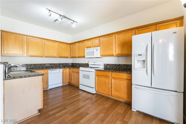 kitchen with visible vents, wood finished floors, white appliances, and dark stone counters
