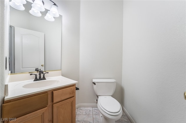 half bath featuring marble finish floor, toilet, vanity, and baseboards