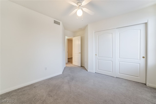 unfurnished bedroom with a closet, baseboards, visible vents, and light colored carpet