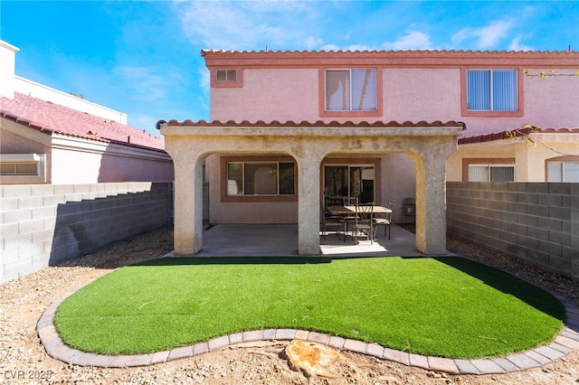 rear view of house with a patio area, a tiled roof, a fenced backyard, and stucco siding