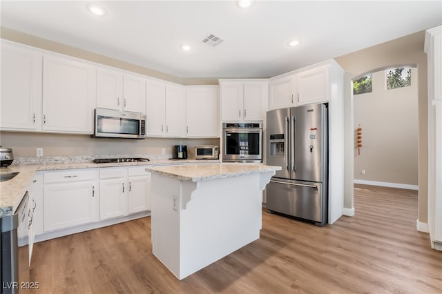 kitchen featuring white cabinets, stainless steel appliances, baseboards, and visible vents