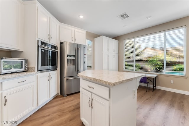 kitchen featuring visible vents, a toaster, light wood-style floors, and appliances with stainless steel finishes