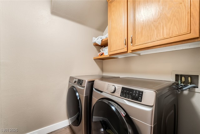 washroom featuring washer and dryer, baseboards, and cabinet space