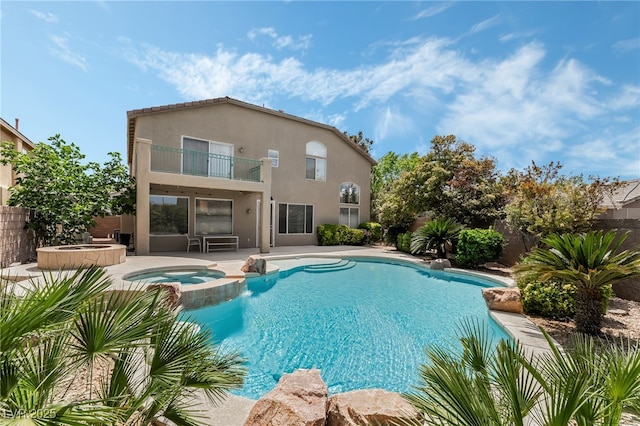 view of pool with fence, a patio, and a pool with connected hot tub