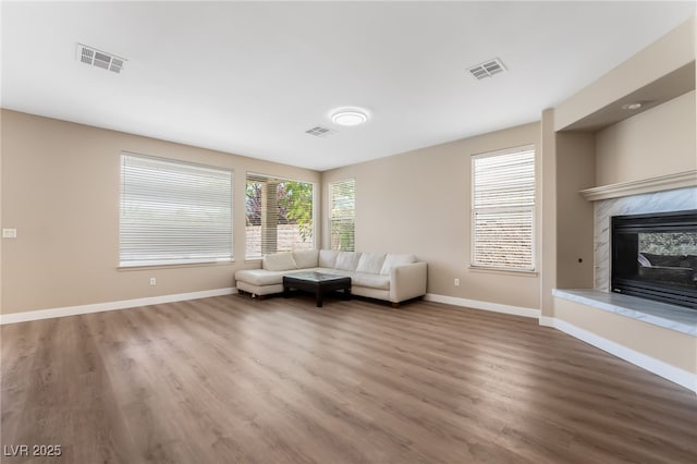 living area with baseboards, wood finished floors, and visible vents
