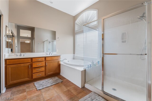 bathroom featuring a bath, a sink, double vanity, and a stall shower