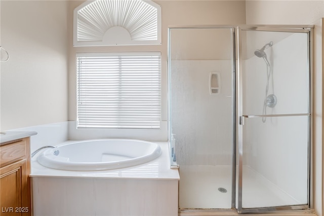 bathroom featuring a bath, vanity, and a shower stall