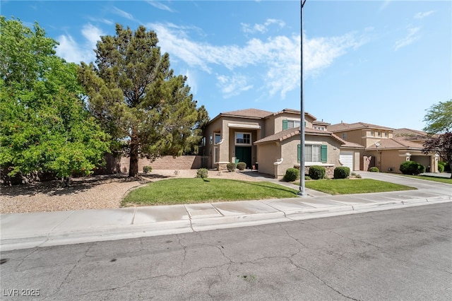 view of front of home with a garage, driveway, a front lawn, and stucco siding
