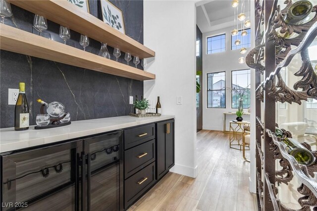 1350 Rossini St, Henderson, NV 89052 - indoor dry bar featuring wine cooler, light wood-style flooring, decorative backsplash, a raised ceiling, and baseboards