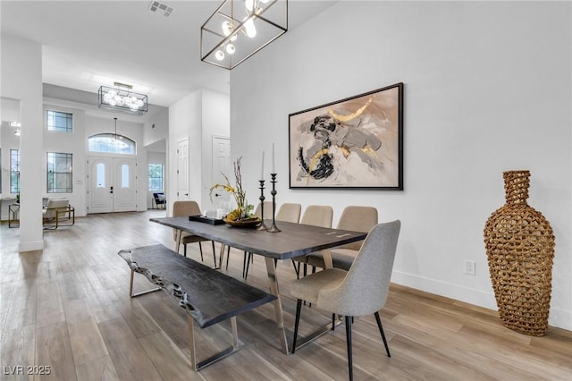 1350 Rossini St, Henderson, NV 89052 - dining space with a chandelier, light wood-type flooring, a towering ceiling, and baseboards
