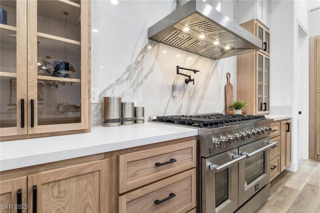 1350 Rossini St, Henderson, NV 89052 - kitchen featuring double oven range, wall chimney exhaust hood, glass insert cabinets, light countertops, and light wood-type flooring