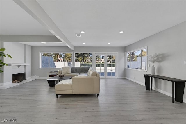 living area with recessed lighting, a wealth of natural light, and baseboards
