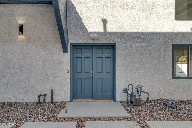 entrance to property featuring stucco siding