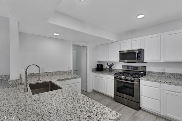 kitchen featuring white cabinetry, a sink, recessed lighting, and appliances with stainless steel finishes