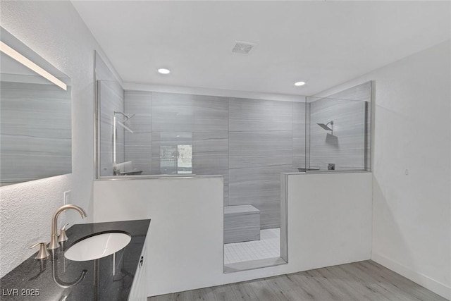 full bath with recessed lighting, wood finished floors, vanity, and a walk in shower