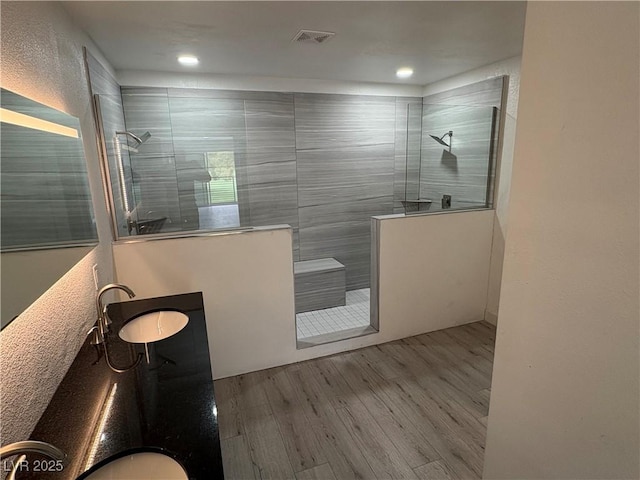full bathroom featuring visible vents, recessed lighting, walk in shower, wood finished floors, and vanity
