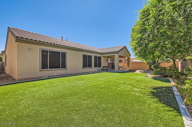 7513 Java Sparrow St, North Las Vegas, NV 89084 - back of property with fence, a tile roof, a lawn, and stucco siding
