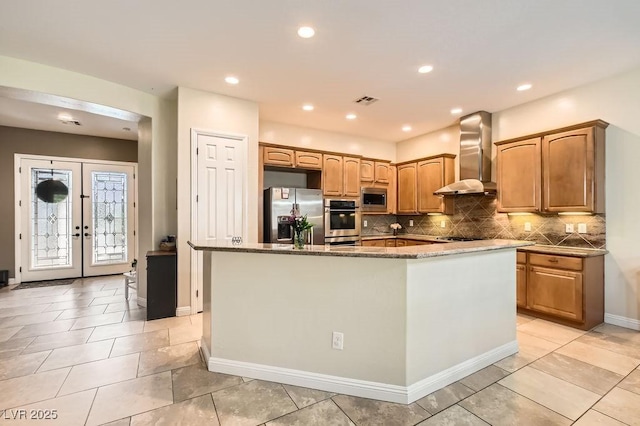 7513 Java Sparrow St, North Las Vegas, NV 89084 - kitchen featuring dark stone counters, visible vents, decorative backsplash, wall chimney range hood, and appliances with stainless steel finishes