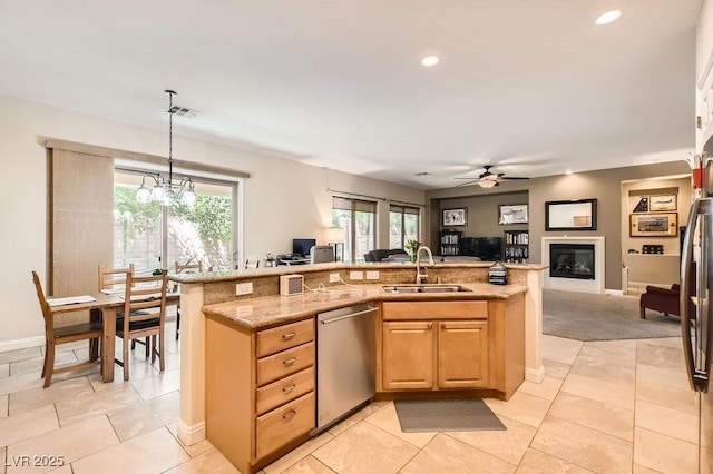 7513 Java Sparrow St, North Las Vegas, NV 89084 - kitchen with light stone counters, dishwasher, a sink, open floor plan, and ceiling fan with notable chandelier