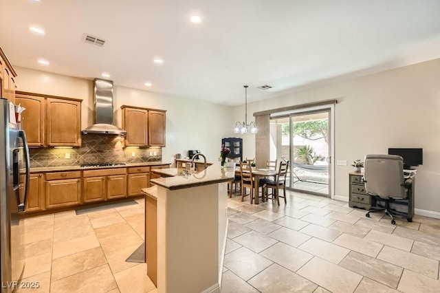 7513 Java Sparrow St, North Las Vegas, NV 89084 - kitchen featuring gas stovetop, backsplash, wall chimney exhaust hood, visible vents, and stainless steel refrigerator with ice dispenser