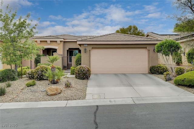 view of front of home with an attached garage, a tile roof, stucco siding, and concrete driveway