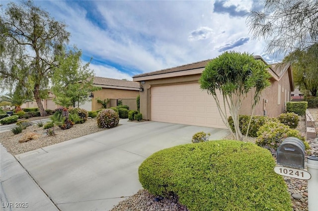 view of front of home featuring stucco siding, an attached garage, and driveway