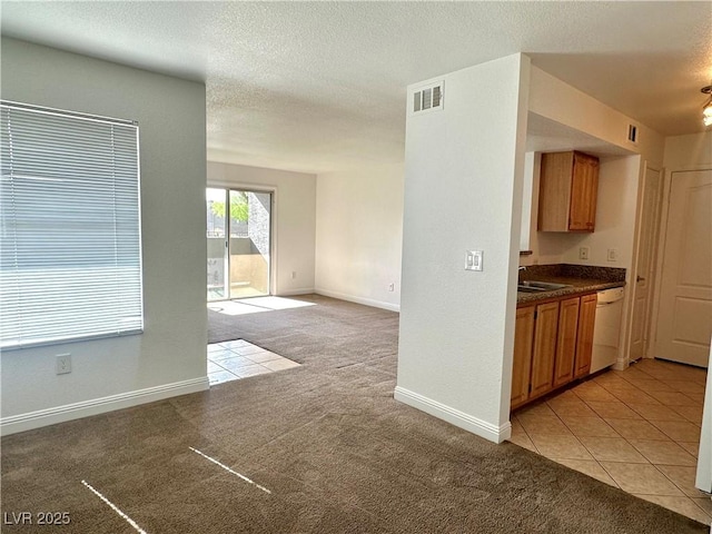 5055 W Hacienda Ave Unit 1095, Las Vegas, NV 89118 - kitchen with dark countertops, white dishwasher, visible vents, and light carpet