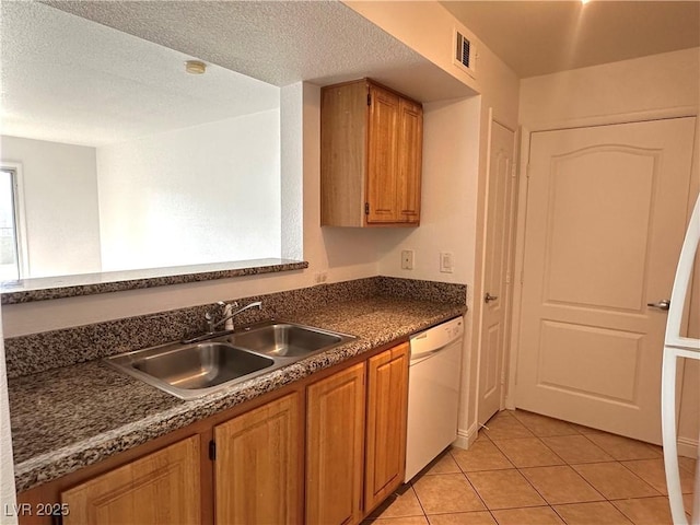 5055 W Hacienda Ave Unit 1095, Las Vegas, NV 89118 - kitchen with dark countertops, dishwasher, visible vents, a sink, and light tile patterned flooring