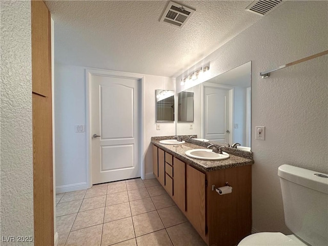5055 W Hacienda Ave Unit 1095, Las Vegas, NV 89118 - bathroom featuring toilet, a sink, visible vents, and a textured ceiling